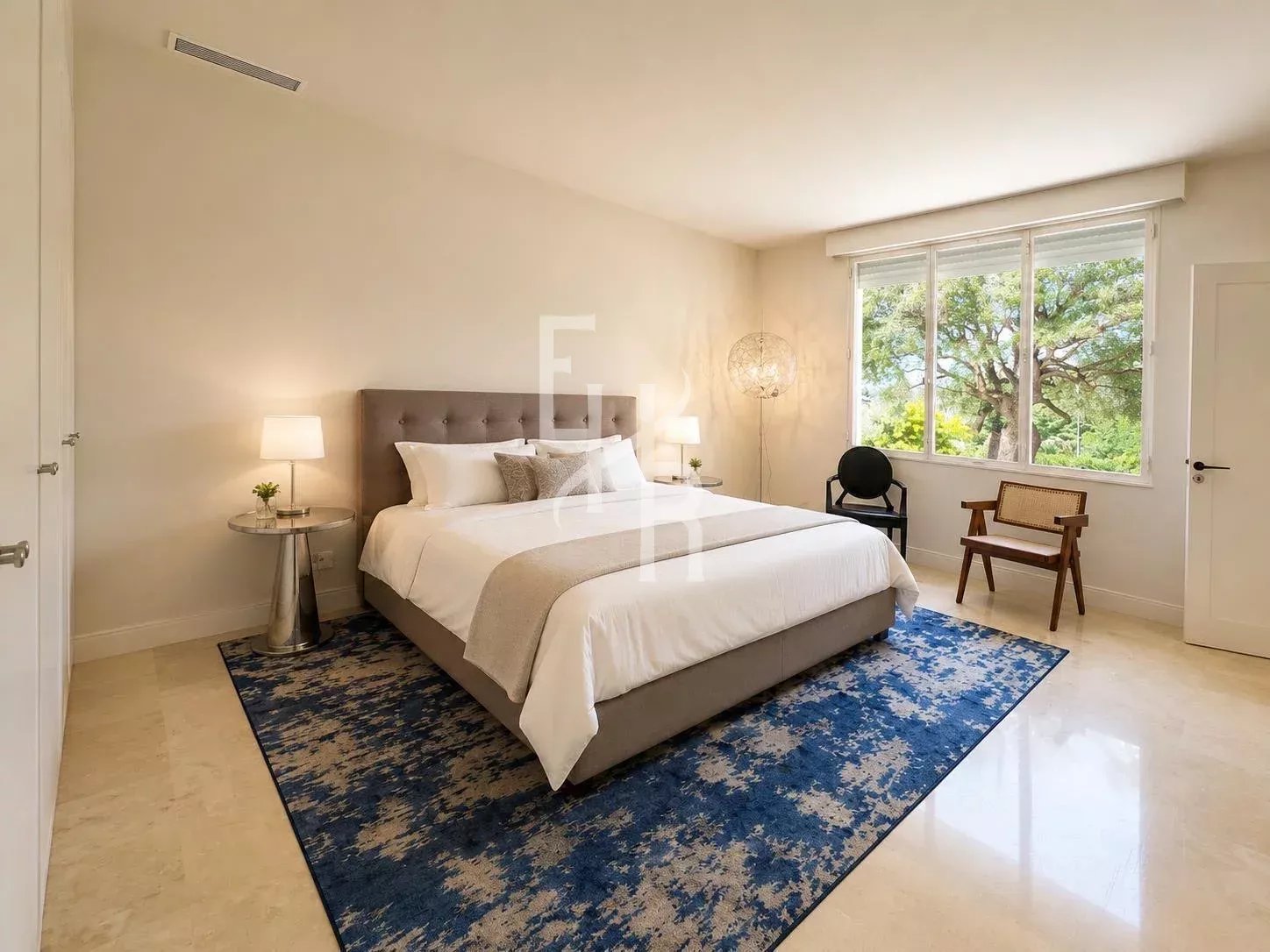 Room in a renovated apartment in Cannes with a double bed, rug and garden view.