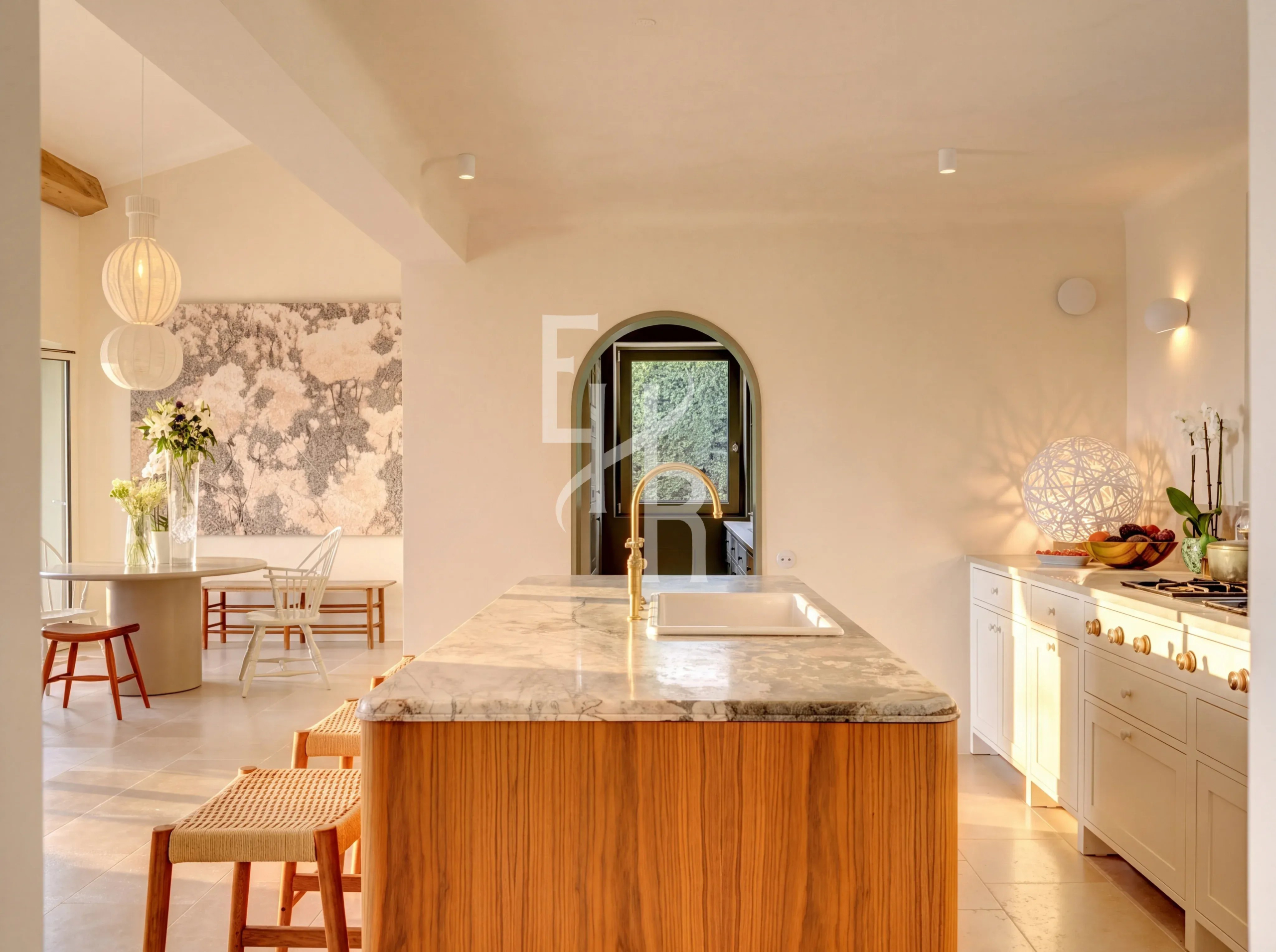 Modern cuisine in Mougins Interior of a modern kitchen with a central marble island and wooden furniture, natural lighting.