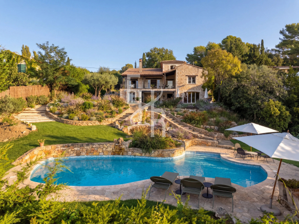 Bastide with swimming pool and garden in Mougins, surrounded by lush vegetation.