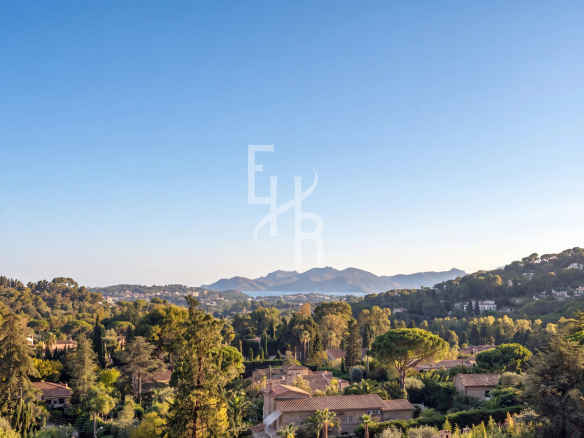 Panoramic view of the hills and vegetation of Mougins, with houses in the background.
