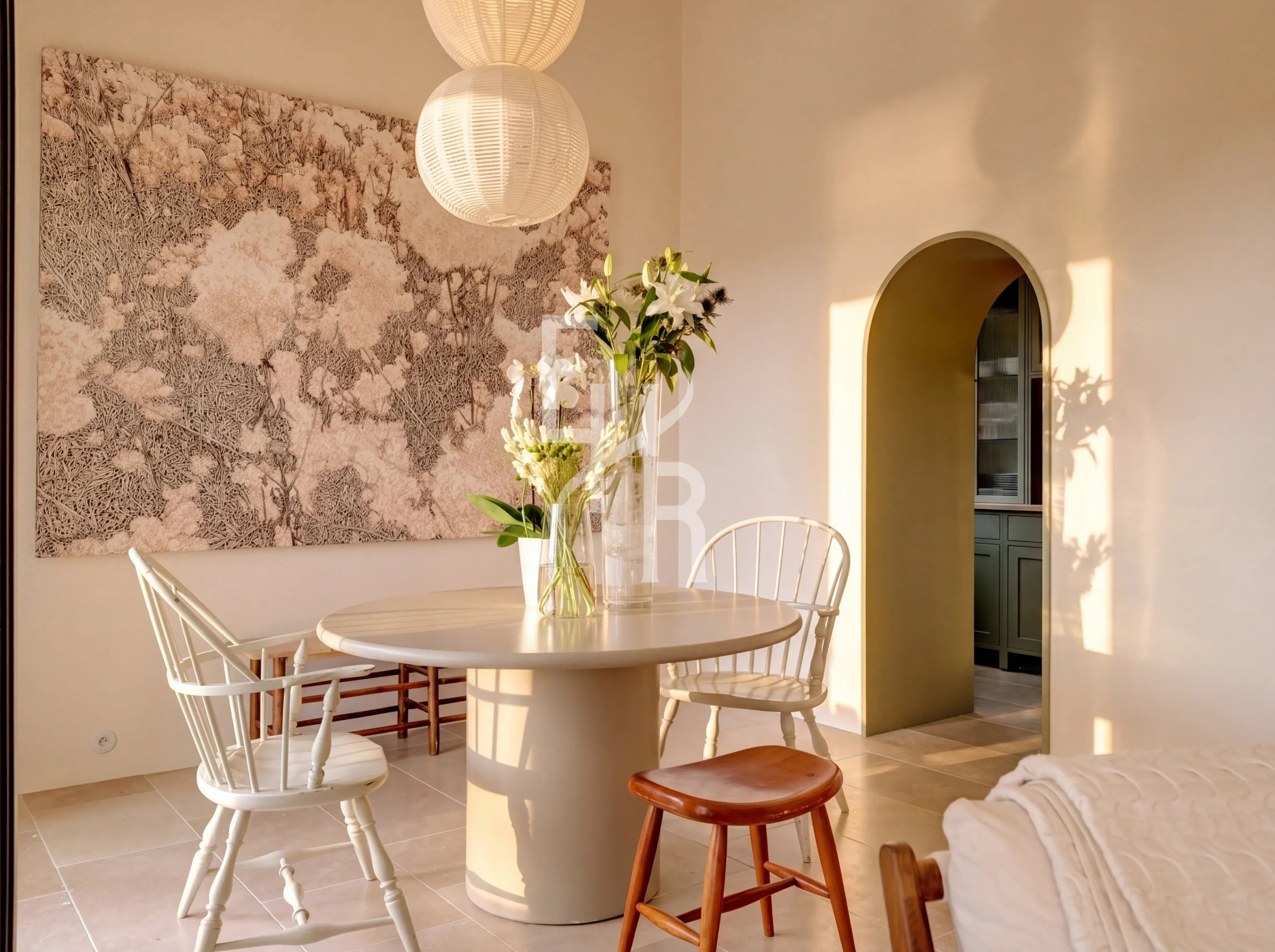 Modern and bright dining room Interior of a bright dining room with a round table and chairs, decorated with flowers and a wall artwork.