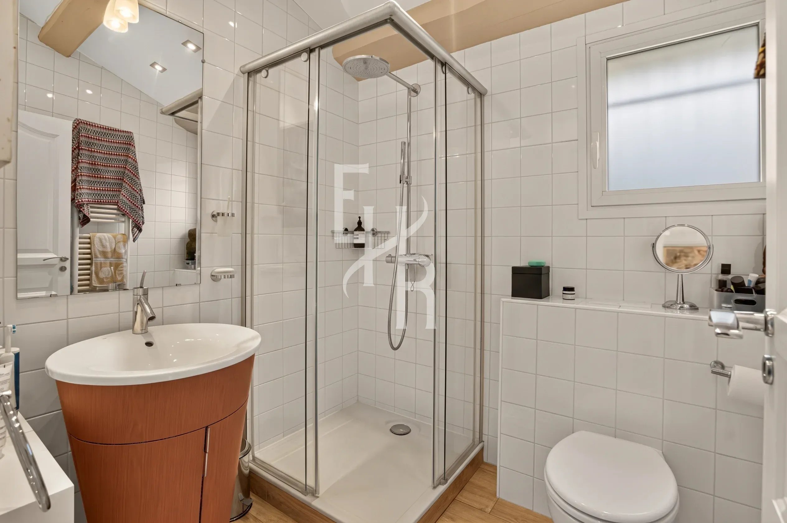 Salle de bain élégante Salle de bain moderne avec douche, lavabo et toilettes, carrelage blanc et bois.
