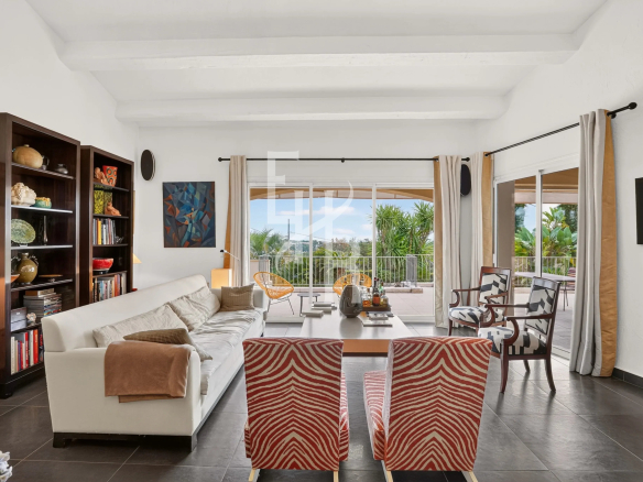 Intérieur d'une villa à Mougins avec salon lumineux et vue sur le jardin.