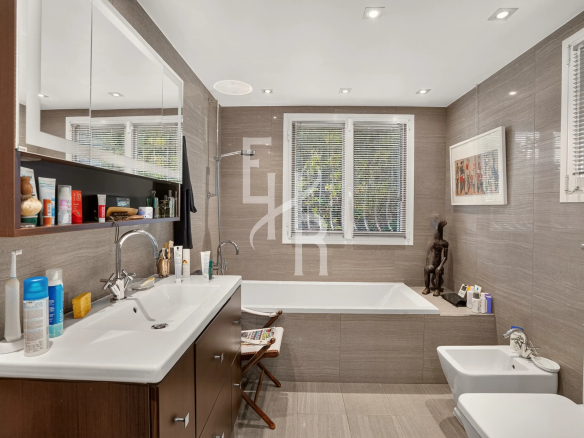 Salle de bain moderne avec baignoire, lavabo et décoration sobre.