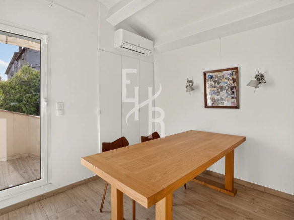 Intérieur d'une villa à Mougins avec une table en bois et des chaises, lumière naturelle.