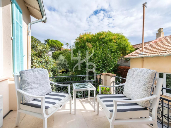 Terrace with comfortable armchairs and views of trees in Cannes.
