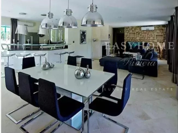 Modern interior of a luxury villa with dining room and open kitchen in Grasse.