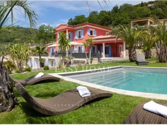 Three luxury villas with swimming pools in an estate in Grasse, surrounded by palm trees and greenery.