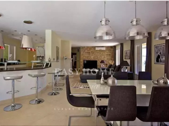 Modern interior of a luxury villa with open kitchen and dining room in Grasse.