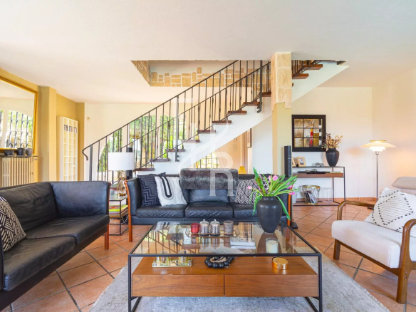 Intérieur d'une villa à Vence avec un grand séjour lumineux et un escalier en colimaçon.
