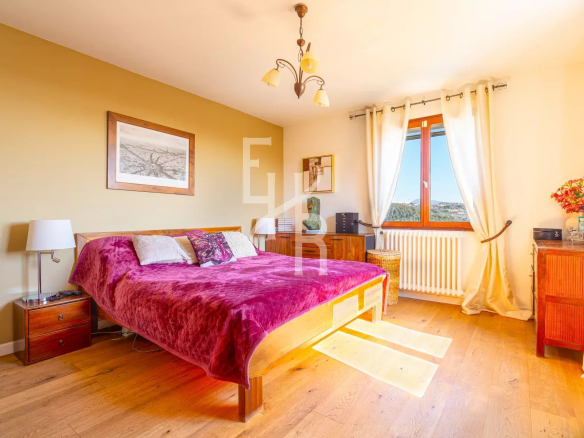 Chambre d'une villa à Vence avec lit double et vue sur les montagnes.