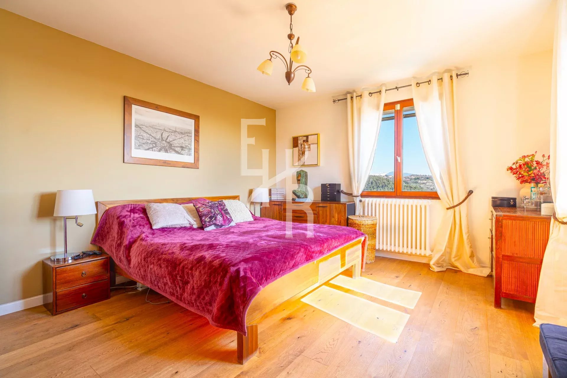 Chambre d'une villa à Vence avec lit double et vue sur les montagnes.