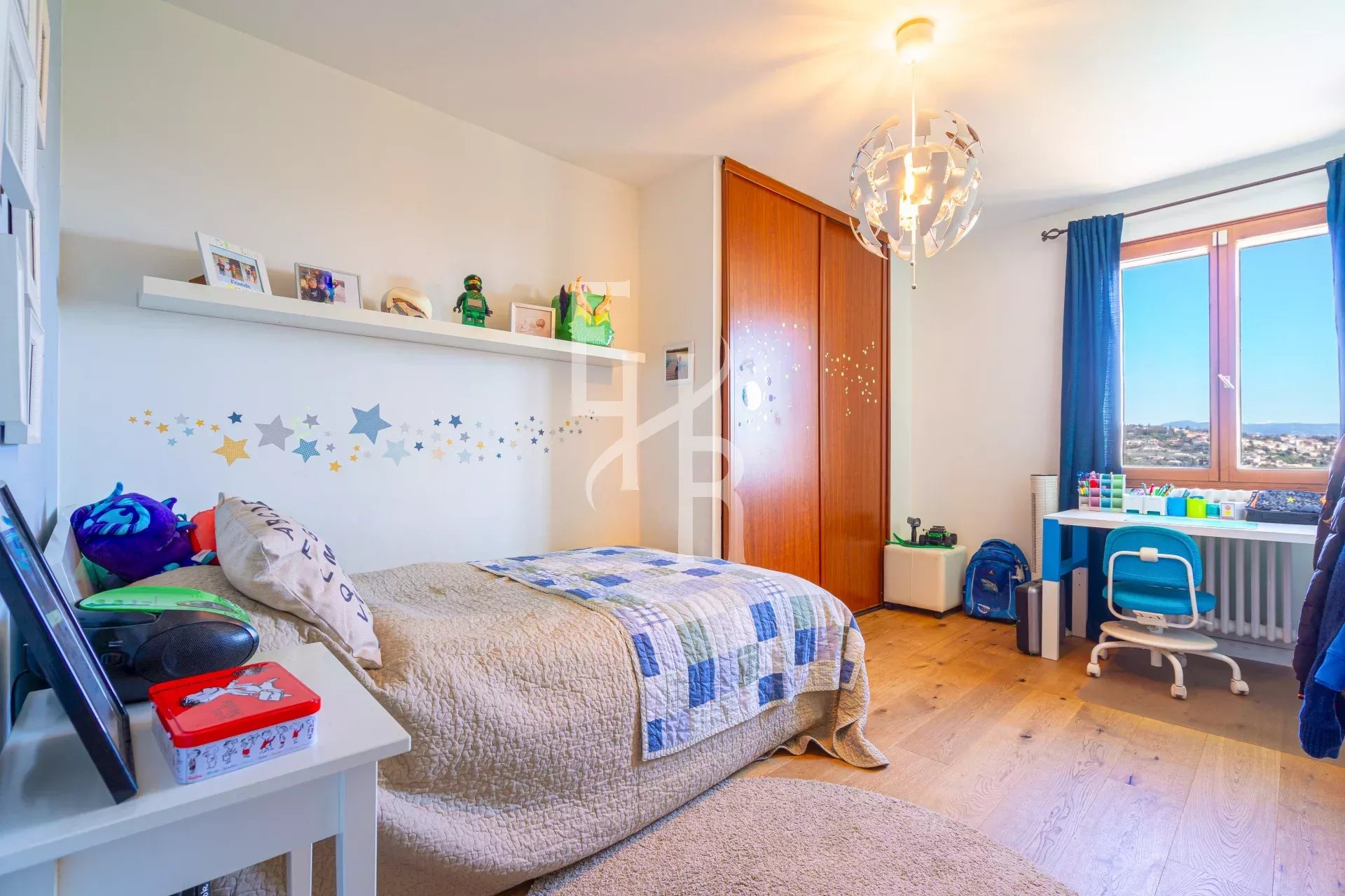 Chambre d'une villa à Vence avec vue sur les montagnes, décorée avec un lit et un bureau.