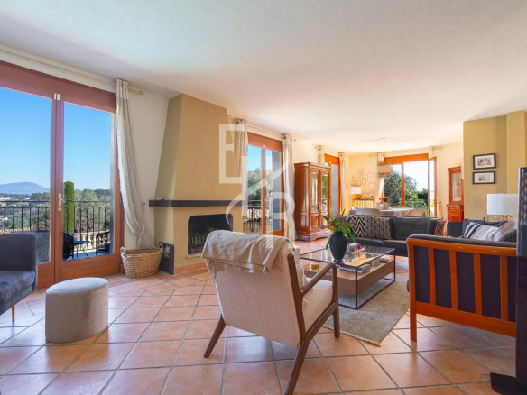 Intérieur lumineux d'une villa à Vence avec vue sur les montagnes, salon et salle à manger ouverts sur la terrasse.