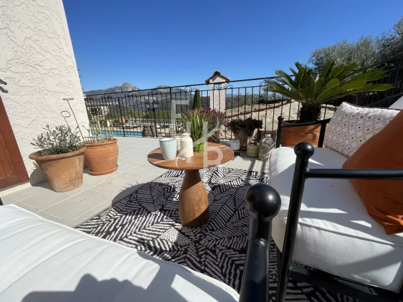 Terrasse d'une villa à Vence avec vue sur les montagnes, mobilier de jardin et plantes.
