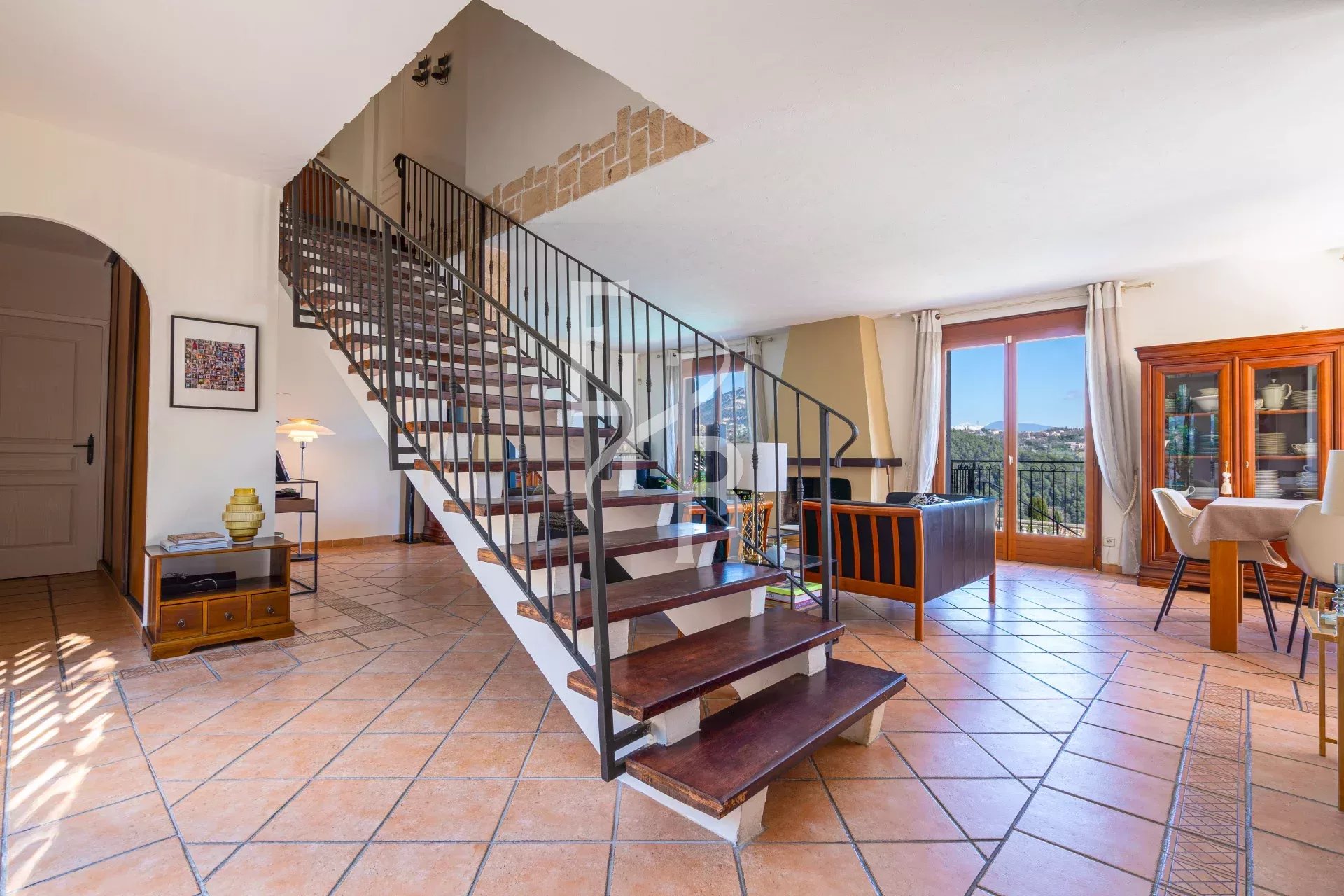 Intérieur d'une villa à Vence avec un escalier et un espace de vie lumineux.
