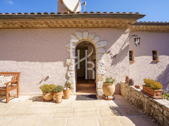 Entrée d'une villa à Vence avec un sol en pierre et des pots de fleurs.