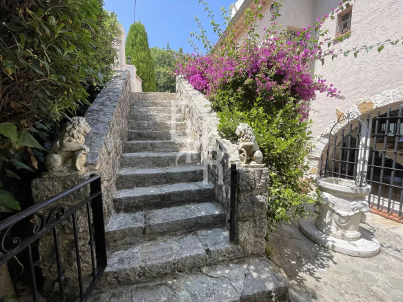 Escaliers en pierre menant à une villa avec des plantes et des fleurs à Vence.