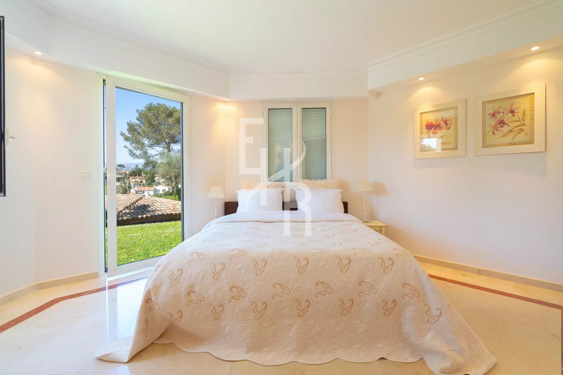 Chambre d'une villa à Mougins avec lit et vue sur l'extérieur.