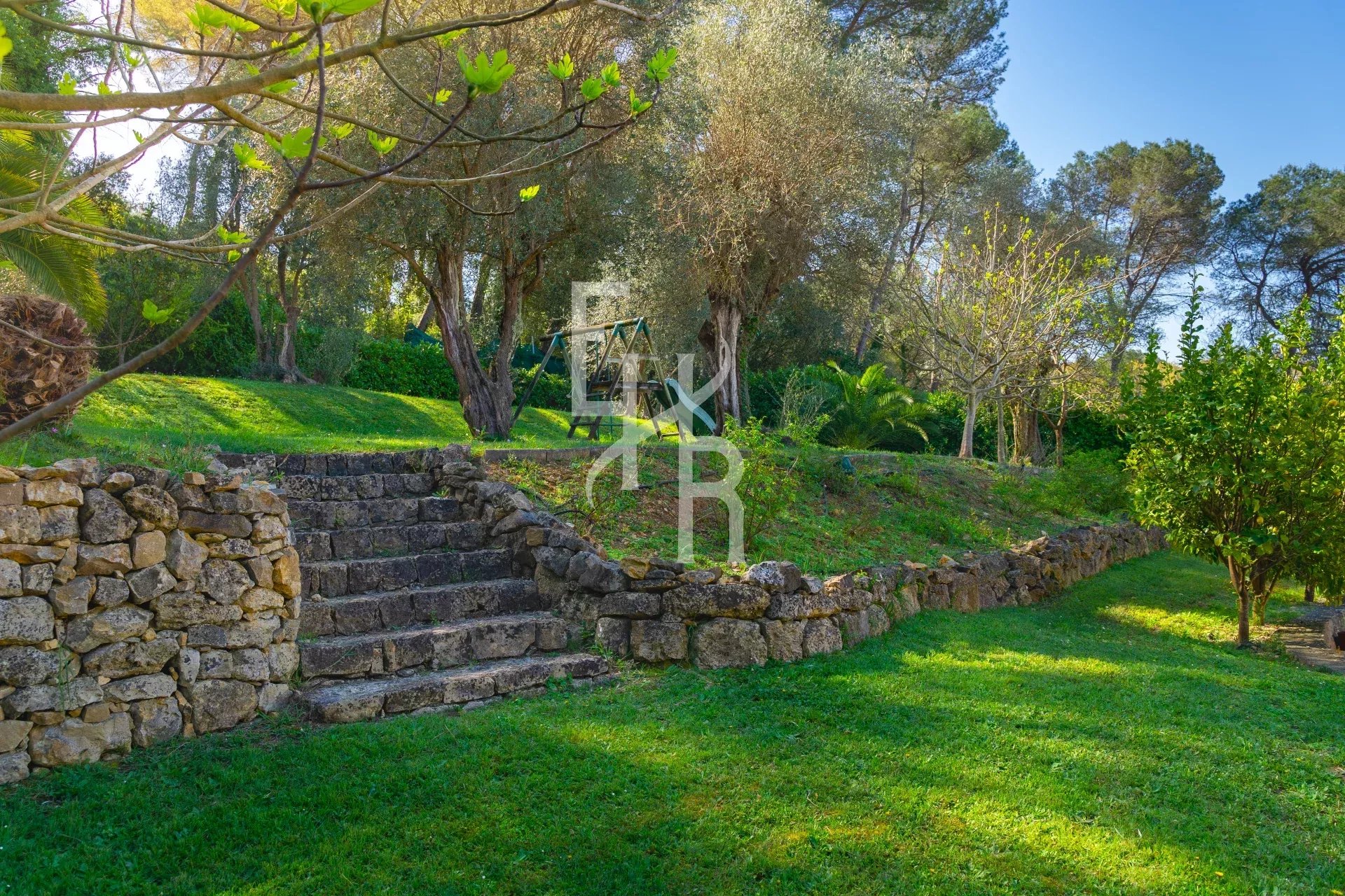 Jardin verdoyant avec des escaliers en pierre à Mougins.