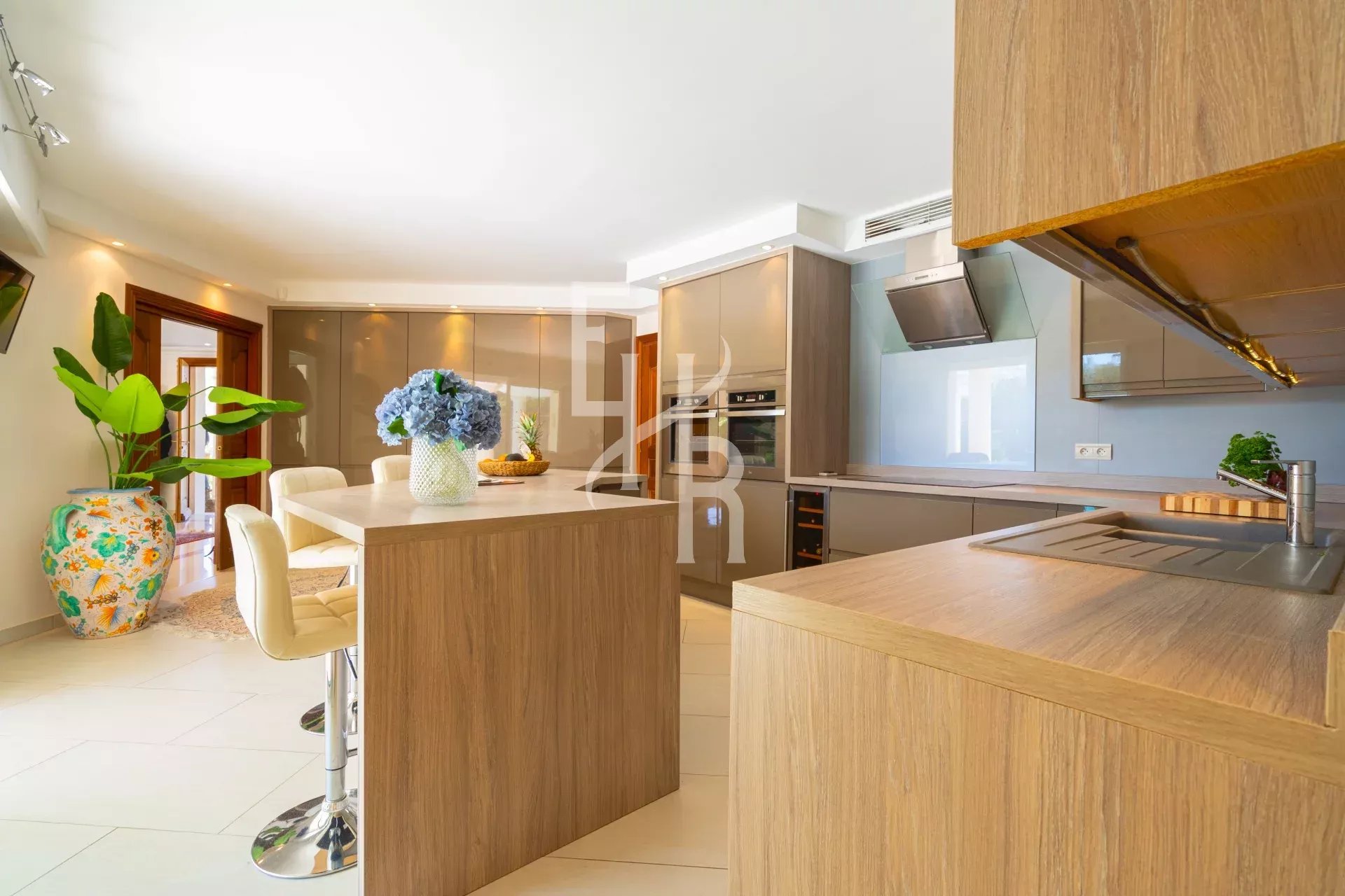 Cuisine moderne avec îlot central et mobilier en bois à Mougins