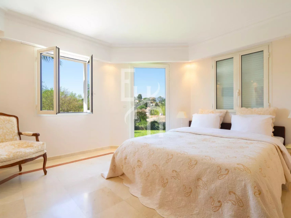 Chambre lumineuse avec lit double et vue sur le jardin, villa à Mougins.