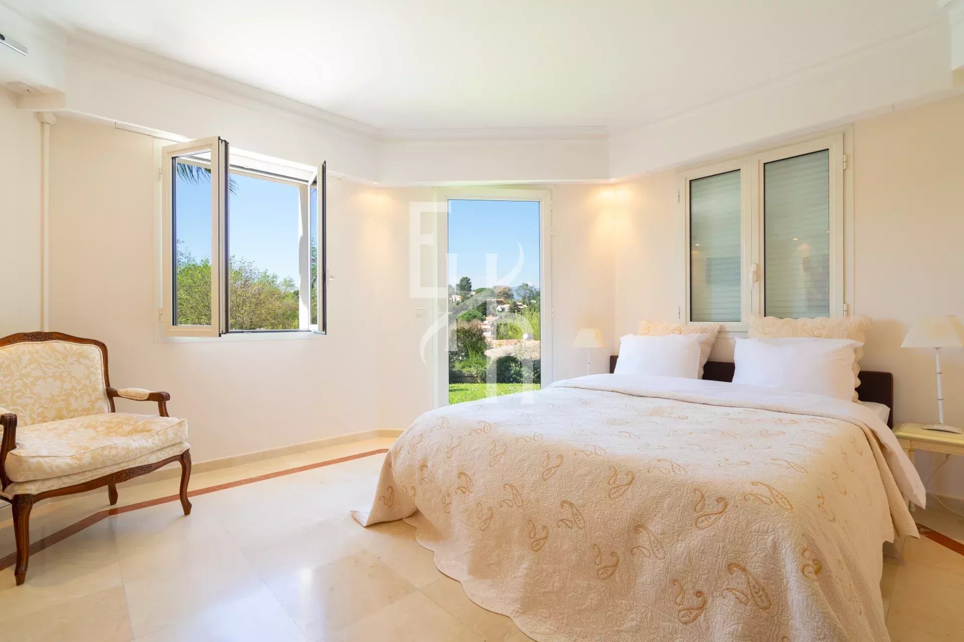 Chambre lumineuse avec lit double et vue sur le jardin, villa à Mougins.