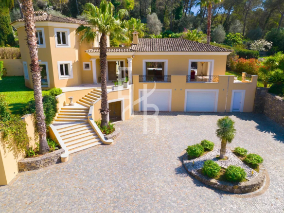 Villa spacieuse avec jardin à Mougins, entourée de palmiers et d'espaces verts.