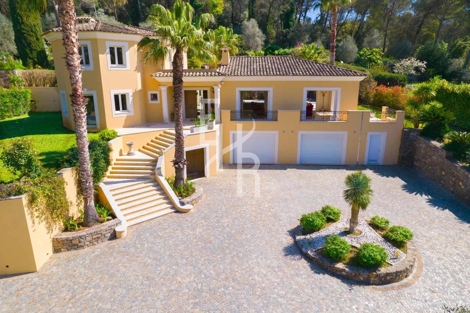 Villa spacieuse avec jardin à Mougins, entourée de palmiers et d'espaces verts.