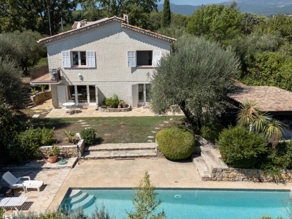 Family villa with swimming pool and terrace, located in Opio near Valbonne, surrounded by trees.
