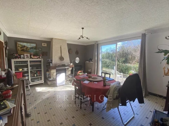 Intérieur d'une villa à Guérande avec salon, cheminée et accès au jardin.