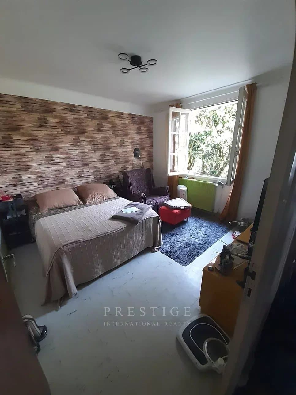 Chambre d'une villa à Guérande avec lit, fauteuil et décoration en bois.