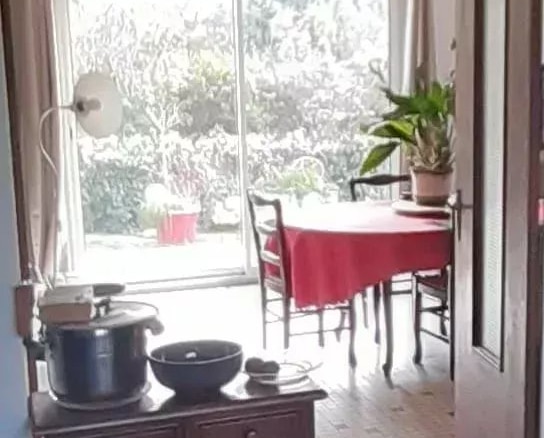 Intérieur d'une villa à Guérande avec une salle à manger lumineuse et des meubles en bois.