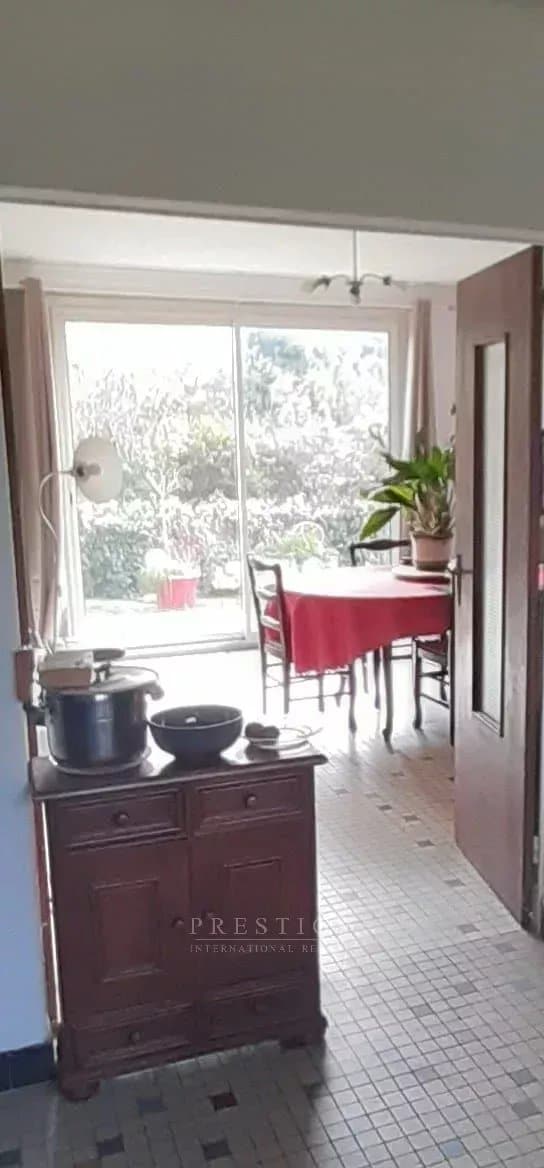 Intérieur d'une villa à Guérande avec une salle à manger lumineuse et des meubles en bois.