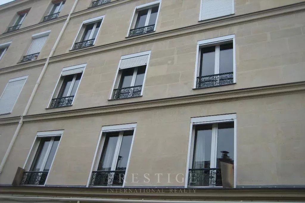 Immeuble en pierre de taille à Paris 16ème Façade d'un immeuble en pierre de taille à Paris 16ème avec fenêtres et balcons.