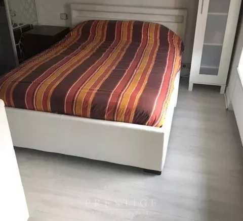 Chambre avec lit double et draps rayés dans un appartement à Paris 16ème.