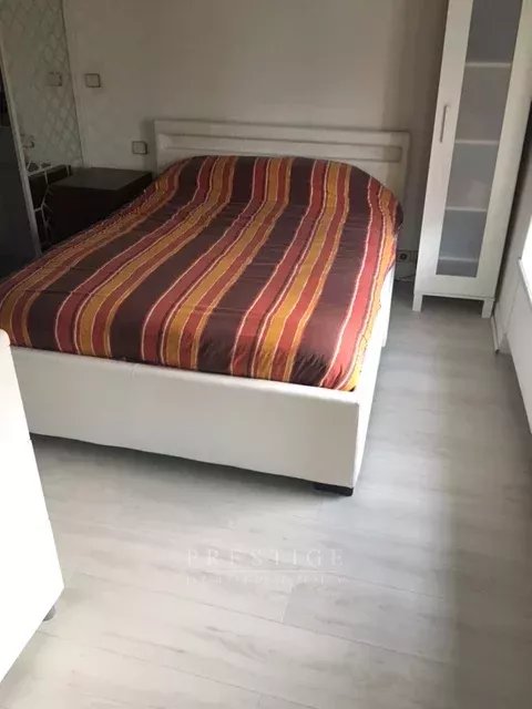 Chambre d’un appartement à Paris 16ème Chambre avec lit double et draps rayés dans un appartement à Paris 16ème.