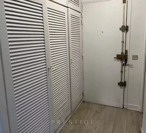 Entrée d'un appartement avec placards intégrés et porte d'entrée sécurisée.