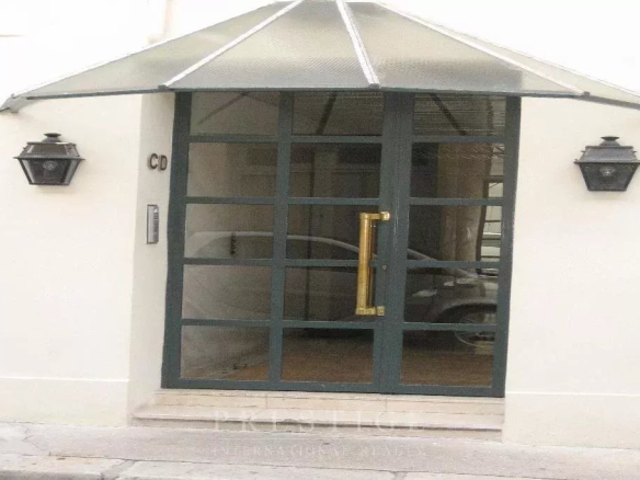 Entrée d'un immeuble en pierre de taille à Paris 16ème, avec porte vitrée et lanternes.