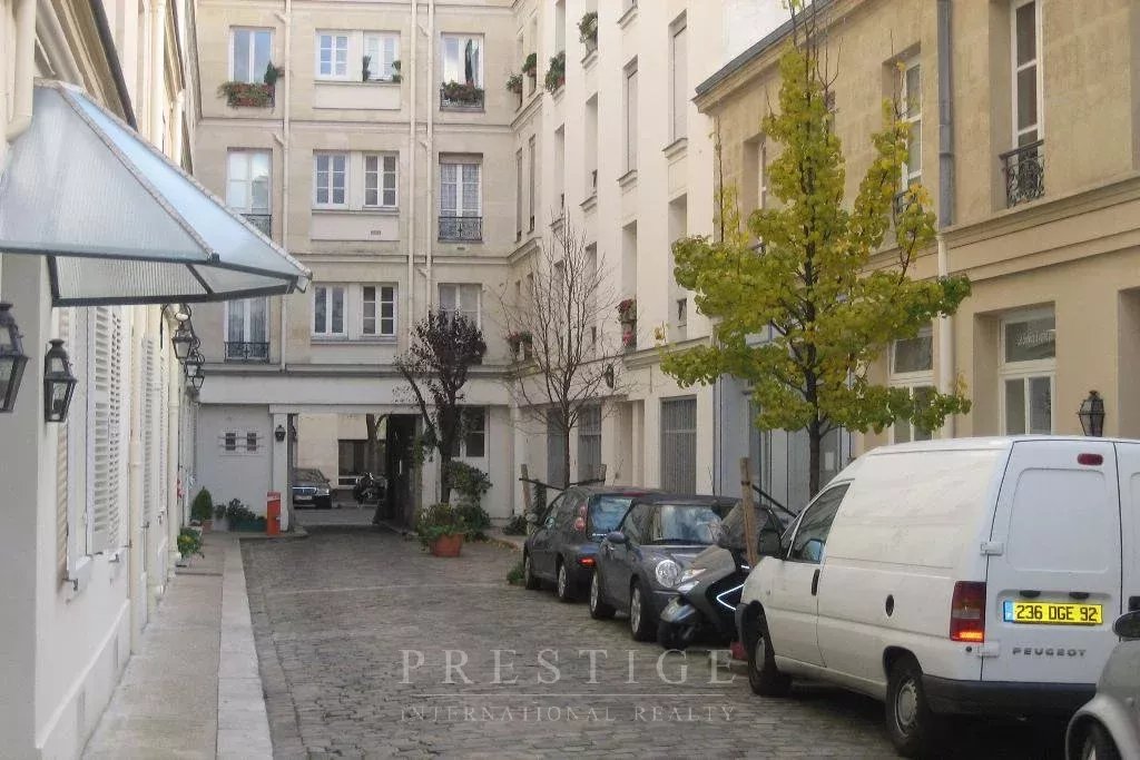 Rue tranquille à Paris 16ème Rue calme avec immeubles en pierre de taille, voitures garées et arbres, Paris 16ème.