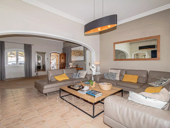 Intérieur d'une villa moderne avec un salon spacieux et lumineux, meubles confortables et décoration élégante.
