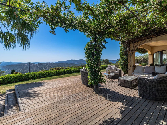Terrasse en bois avec mobilier de jardin et vue panoramique sur la mer et les collines au Tignet.