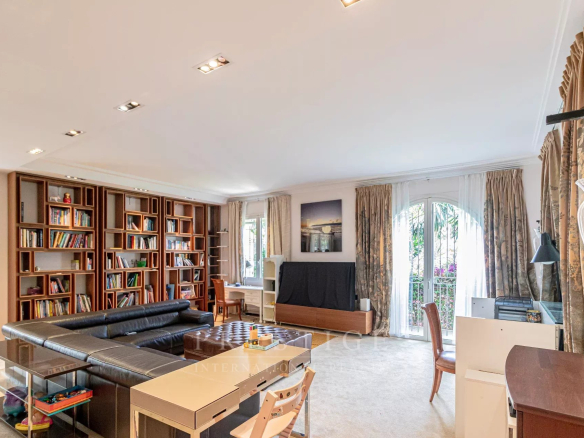Intérieur d'une villa luxueuse à Cap d'Antibes, salon avec bibliothèque et espace de travail.