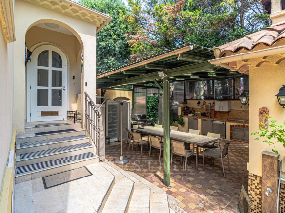 Entrée d'une villa rénovée à Cap d'Antibes avec terrasse et cuisine extérieure.