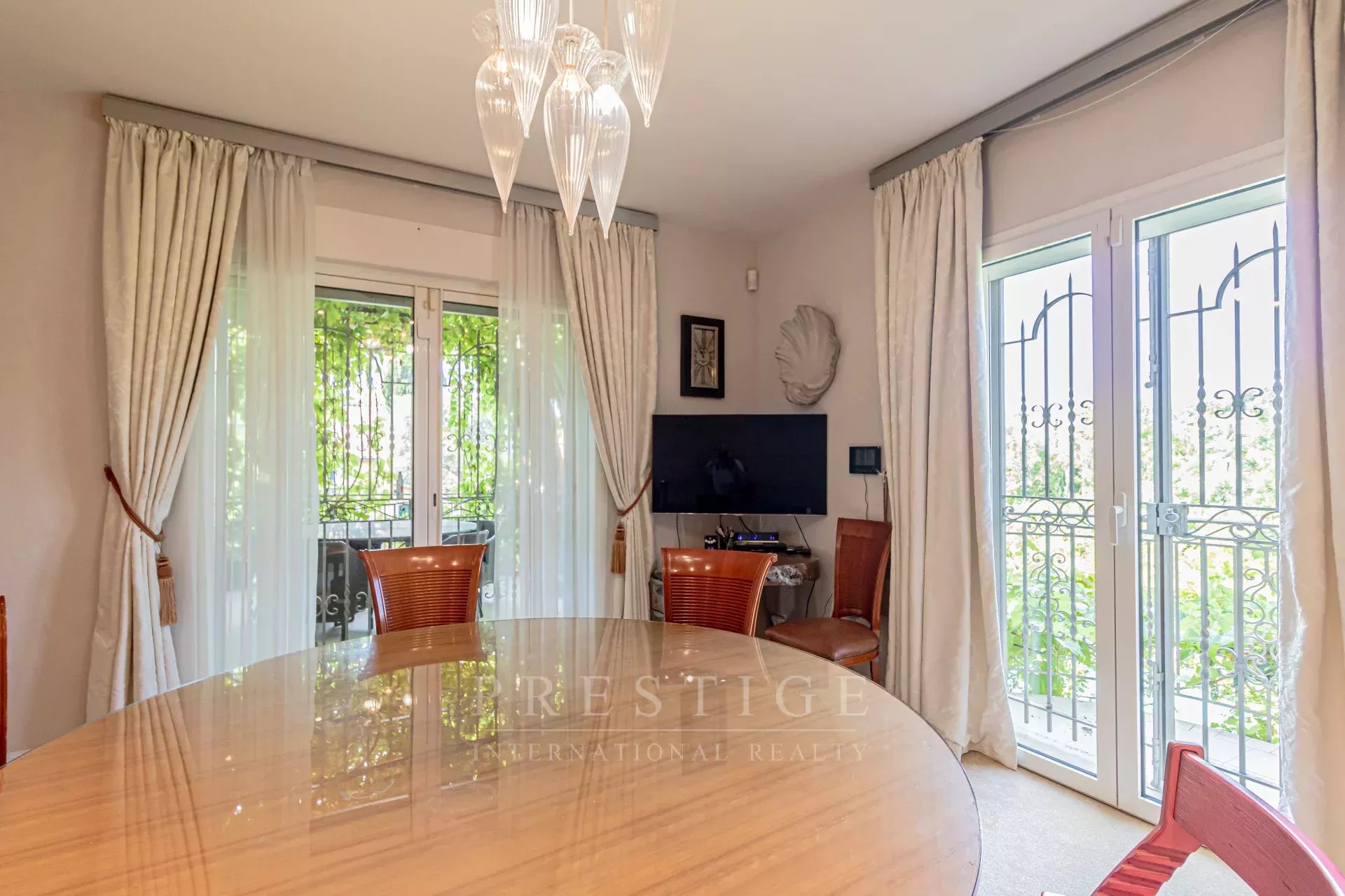 Salle à manger d’une villa à Cap d’Antibes Intérieur d'une villa luxueuse à Cap d'Antibes, salle à manger avec vue sur l'extérieur.