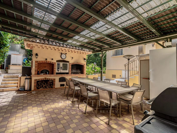 Terrasse extérieure d'une villa avec barbecue et table à manger, Cap d'Antibes.