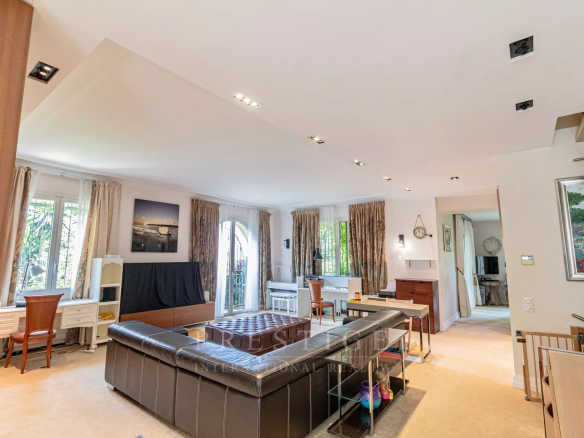 Intérieur d'une villa luxueuse à Cap d'Antibes, salon spacieux et lumineux, mobilier moderne.