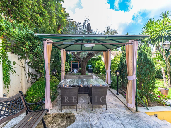 Terrasse avec pergola et mobilier de jardin dans une villa au Cap d'Antibes.