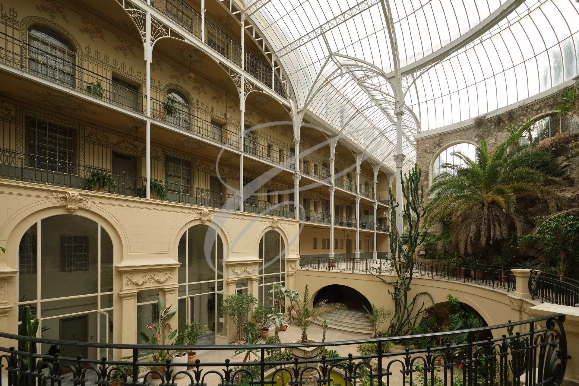 Interior of a Belle Epoque palace in Beausoleil, with a glass roof and exotic plants.