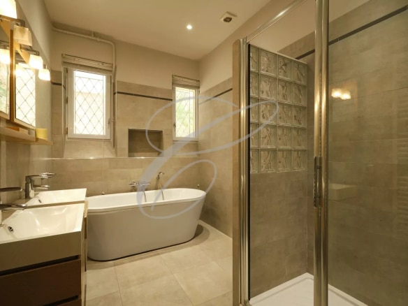 Modern bathroom with bathtub, shower and sink in an apartment in Beausoleil.